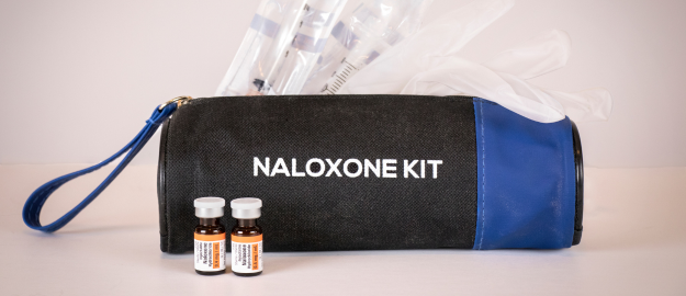 A small bag containing Naloxone, syringes and latex gloves